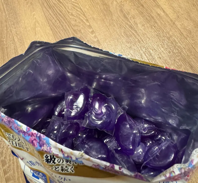 チャックを開けたジェルボール詰め替え袋の中身。紫色の粒が並んでいる